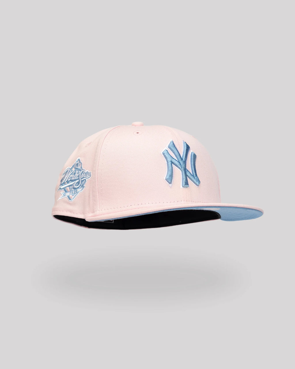 Gorra New Era 59FIFTY New York Yankees rosada con NY azul cielo y parche Serie Mundial 1999